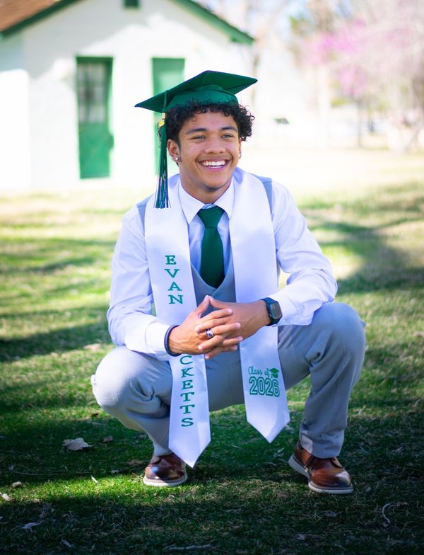Senior posing confidently in graduation gown