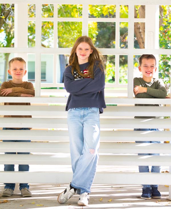 Three siblings posing together at a gazebo