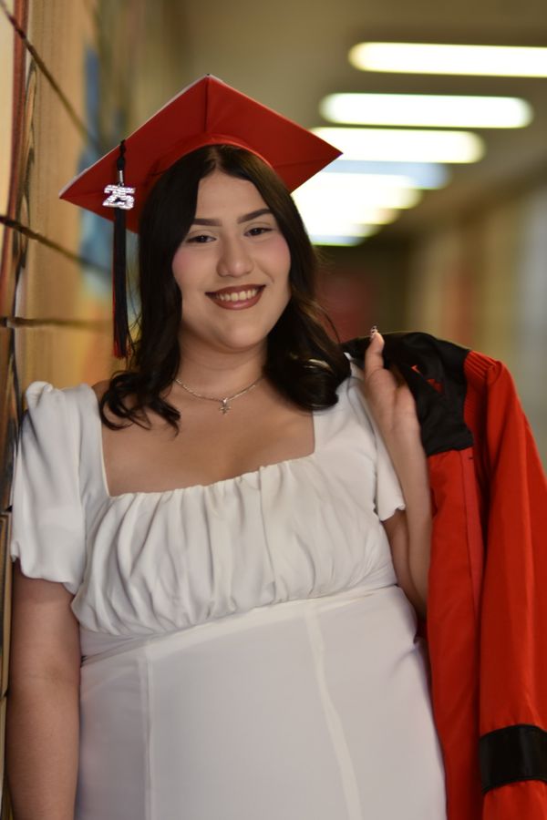 Young woman in a red graduation cap and gown