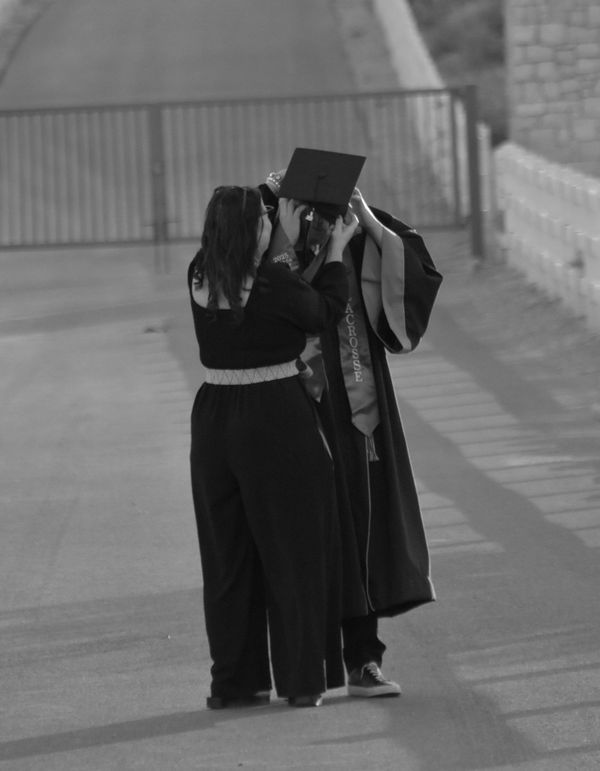 Black and white graduation portrait with a loving embrace