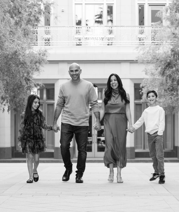 Black and white family of four holding hands