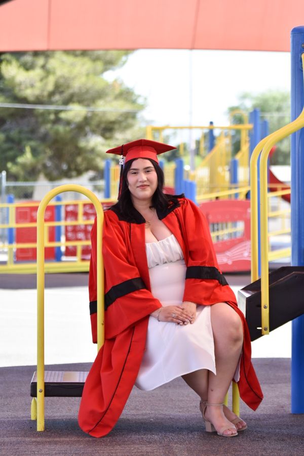 Graduate posing playfully on a playground