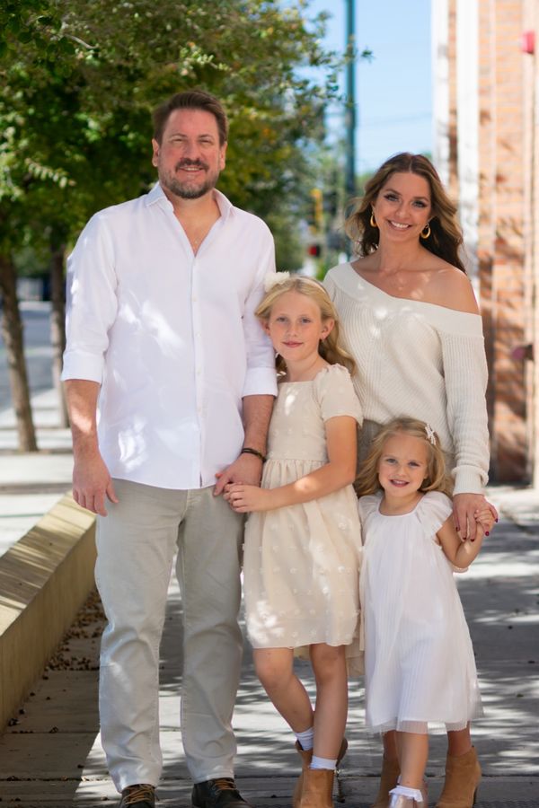 Family of four walking together on a sidewalk