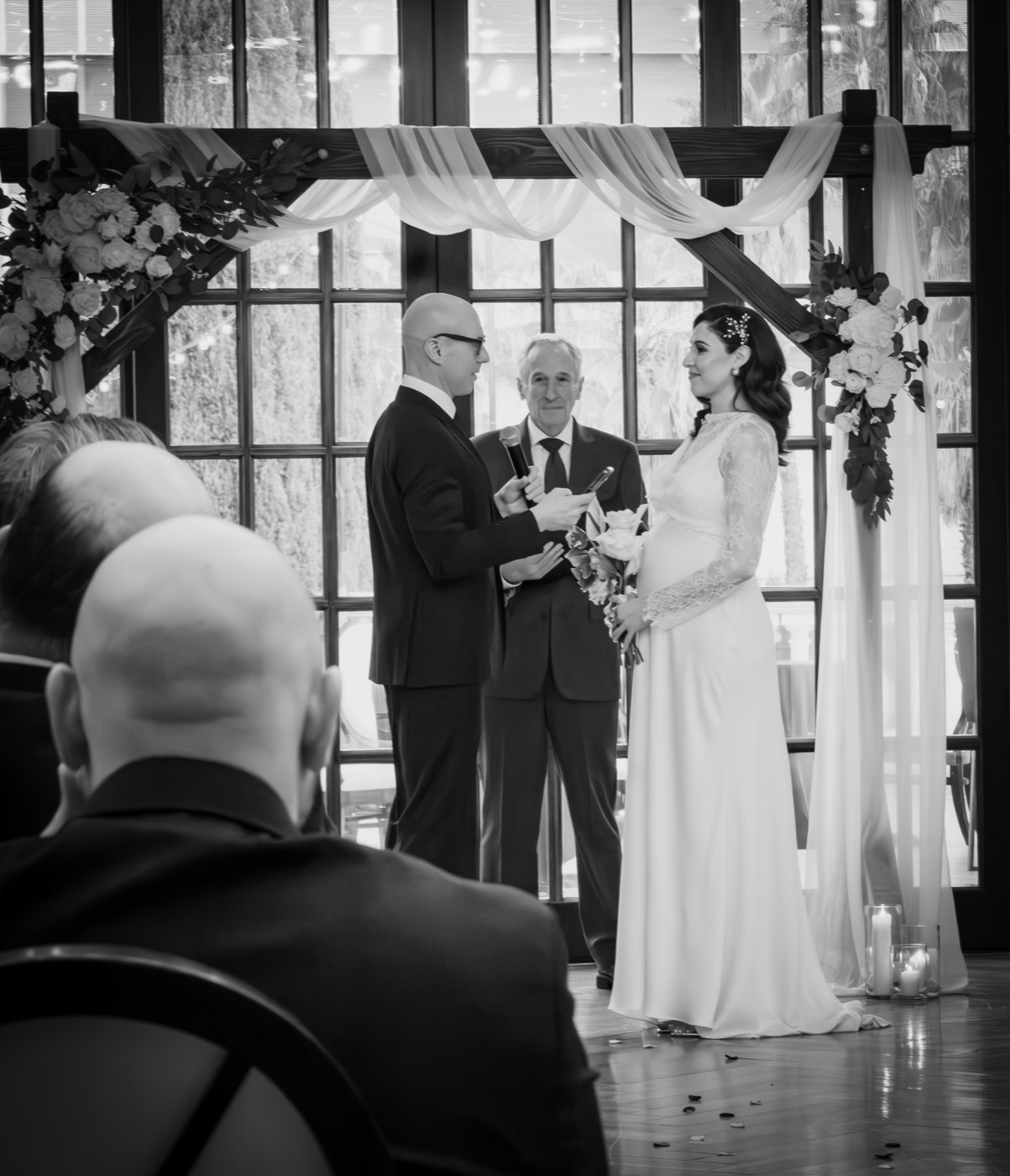 Black and white wedding ceremony with bride and groom at the altar