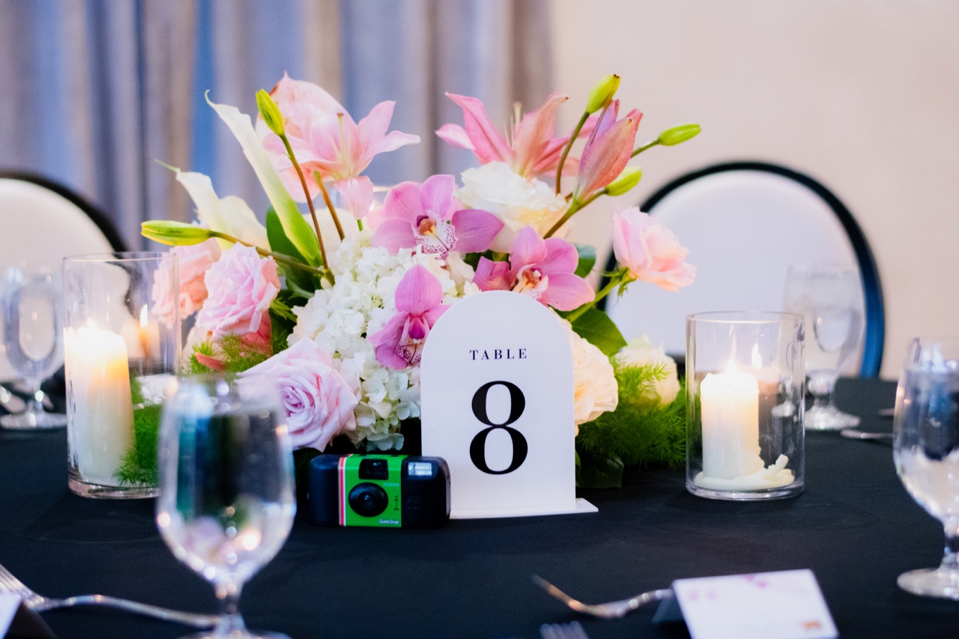 Elegant table setting with floral centerpiece and candles at a wedding reception